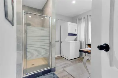 a glass shower in a kitchen with a refrigerator at Lovely Muskoka Waterfront Cottage-Hot tub & Sauna! in Bracebridge