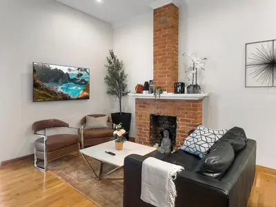 a living room with a couch and a fireplace at Historic Victorian with Deck and Parking in Toronto
