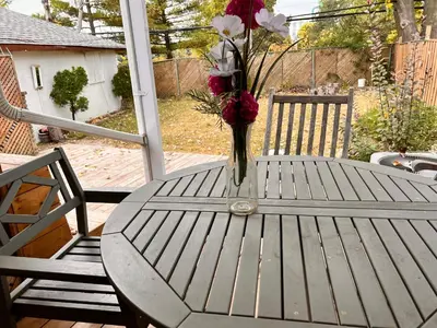 a vase of flowers sitting on a table on a porch at 3 BR GREAT HOUSE WITH ONE parking in Richmond Hill