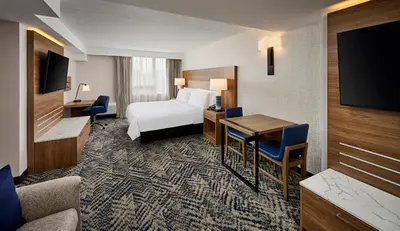 a hotel room with a bed and a desk at Candlewood Suites Burlington Conference Centre by IHG in Burlington
