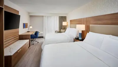 a hotel room with two beds and a desk at Candlewood Suites Burlington Conference Centre by IHG in Burlington
