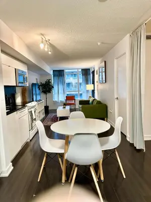 a kitchen and living room with a table and chairs at Lush Condo By CNTower - Free Parking in Toronto