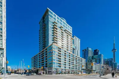 a tall glass building in a city at Lush Condo By CNTower - Free Parking in Toronto
