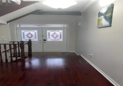 an empty room with a staircase and two windows at Beautiful private Room near Toronto pearson Airport in Brampton