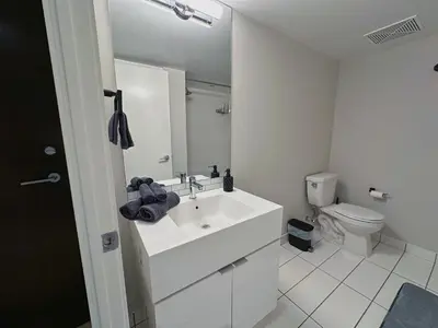 a white bathroom with a sink and a toilet at Downtown 2 bedroom Gem with Free Parking in Toronto