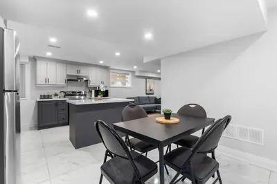a kitchen and dining room with a table and chairs at Urban Haven: 2BR/2BA+Office, Kitchen, Dining in Newcastle
