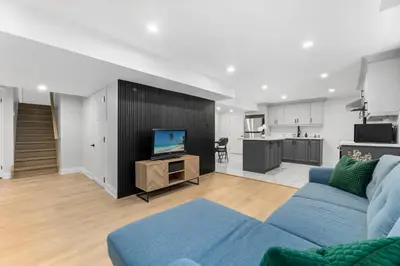 a living room with a blue couch and a kitchen at Urban Haven: 2BR/2BA+Office, Kitchen, Dining in Newcastle