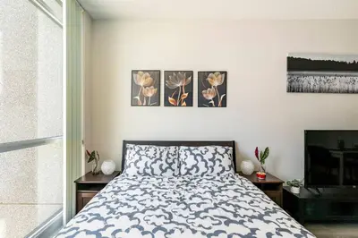 a bedroom with a bed and three paintings on the wall at Luxury Suites Steps to CN Tower - Lock in 4 Weeks Enjoy Half OFF in Toronto