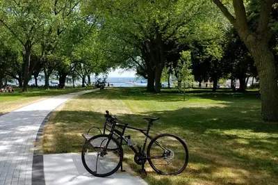 a bike parked on the grass next to a park at Luxury Suites Steps to CN Tower - Lock in 4 Weeks Enjoy Half OFF in Toronto
