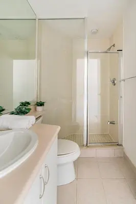 a white bathroom with a toilet and a shower at Luxury Suites Steps to CN Tower - Lock in 4 Weeks Enjoy Half OFF in Toronto