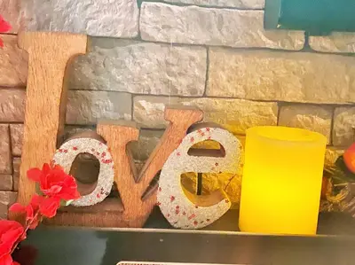 a wooden sign that says love next to a candle at LOVE and Relax at Dream Catcher Retreat in Whitby