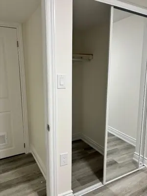 a mirror in a room next to a closet at Bright Queen Room close to Sheridan College and Airport in Brampton