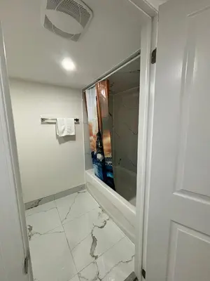 a bathroom with a walk in shower and a mirror at Bright Queen Room close to Sheridan College and Airport in Brampton