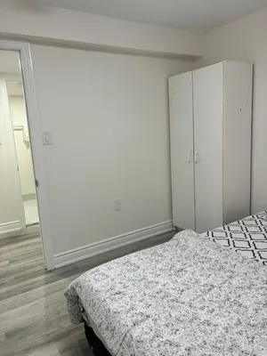 a white bedroom with a bed and a closet at Bright Queen Room close to Sheridan College and Airport in Brampton