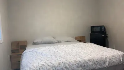 a bedroom with a bed and a tv on a wall at Bright Queen Room close to Sheridan College and Airport in Brampton