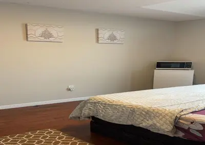 a bedroom with a bed and a refrigerator at Bright Queen Room close to Sheridan College and Airport in Brampton