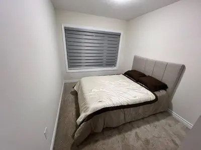 a small bed in a room with a window at Niagara's entertainment house in Thorold