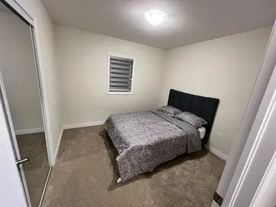 a small bedroom with a bed and a window at Niagara's entertainment house in Thorold