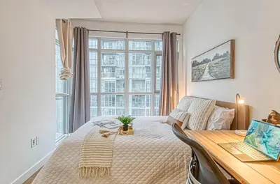 a bedroom with a bed and a desk and a window at The Snug 1plus1 Suite with Free Parking in Toronto