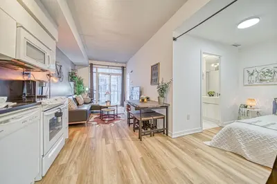 a kitchen and living room with a bed and a table at The Snug 1plus1 Suite with Free Parking in Toronto