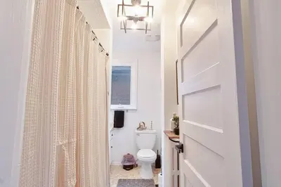 a white bathroom with a toilet and a window at Exquisite Luxury Estate - Steps to Downtown in Toronto