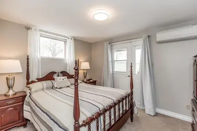 a bedroom with a bed and two windows at Mountain Ash Country Manor and Spa in Creemore