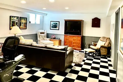 a living room with a couch and a tv at Mountain Ash Country Manor and Spa in Creemore