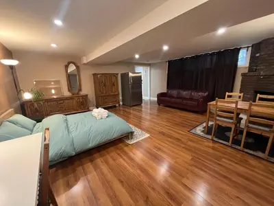 a living room with a bed and a dining room at Entire Basement Apartment in Mississauga, Etobicoke in Mississauga