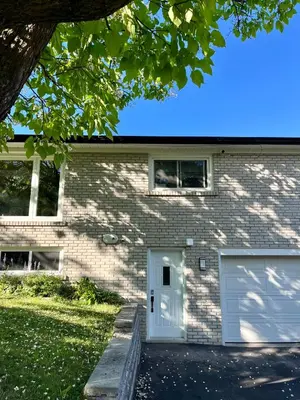 a brick house with a white garage at Entire Basement Apartment in Mississauga, Etobicoke in Mississauga