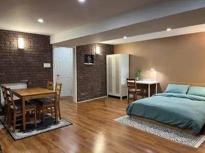 a bedroom with a bed and a dining room with a table at Entire Basement Apartment in Mississauga, Etobicoke in Mississauga