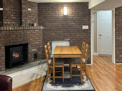 a dining room with a table and a fireplace at Entire Basement Apartment in Mississauga, Etobicoke in Mississauga