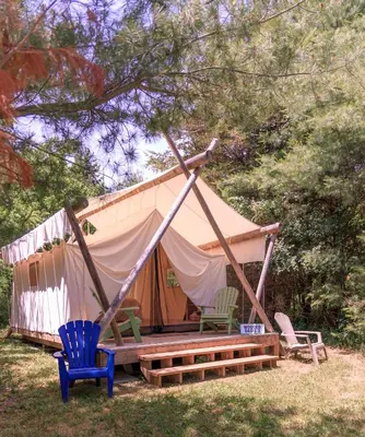 a tent with a porch and two chairs in a yard at Homegrown Hideaway in Port Dover