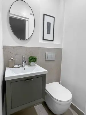 a bathroom with a sink and a toilet and a mirror at Elegant 2 Bedroom with Parking in Toronto
