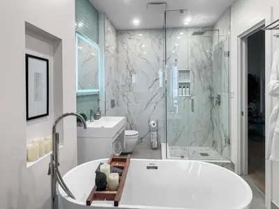 a white bathroom with a tub and a shower at Elegant 2 Bedroom with Parking in Toronto
