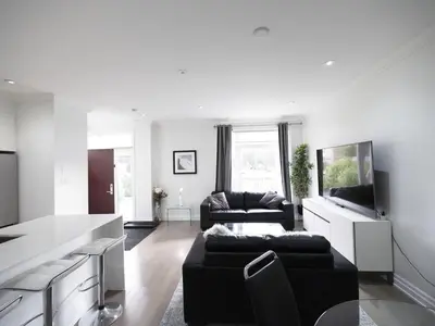 a living room with a couch and a tv at Executive 3 Bedroom Town House in Mississauga