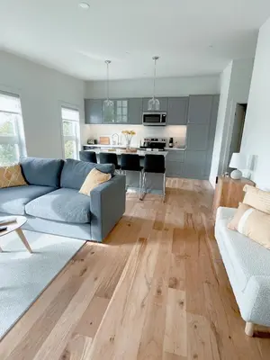 a living room with a blue couch and a kitchen at Elora’s Irvine River Suite in Elora