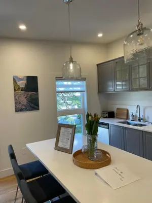 a kitchen with a table with a vase of flowers on it at Elora’s Irvine River Suite in Elora