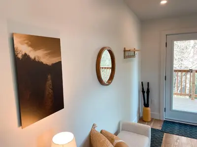 a living room with a mirror and a couch at Elora’s Irvine River Suite in Elora