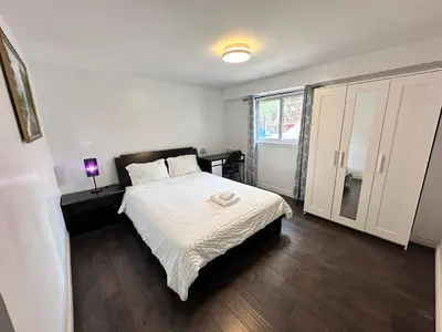 a bedroom with a bed and a large window at Riverwood Home in Mississauga
