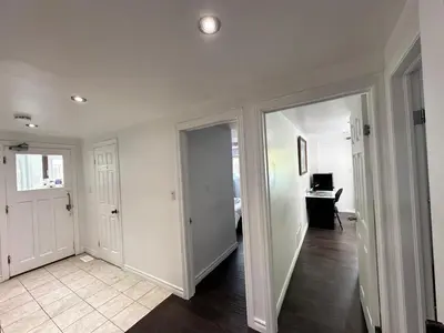 a hallway with white walls and a room with a desk at Riverwood Home in Mississauga