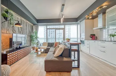 a living room with a couch and a kitchen at Skyline Retreat Residences in Toronto