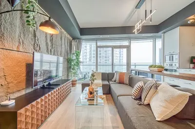 a living room with a couch and a flat screen tv at Skyline Retreat Residences in Toronto