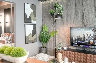 a living room with a tv on a wall at Skyline Retreat Residences in Toronto