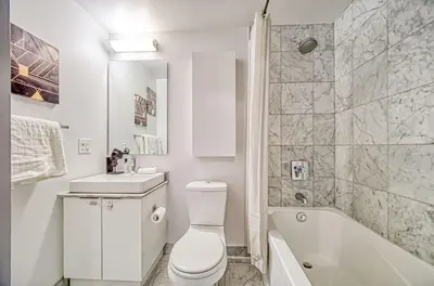 a bathroom with a toilet and a sink and a tub at Skyline Retreat Residences in Toronto