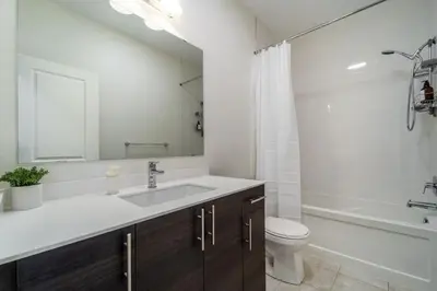a bathroom with a sink and a toilet and a tub at Luxury Urban Town home in Oakville