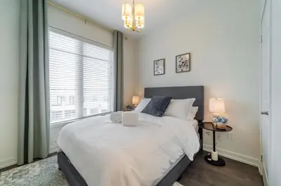 a bedroom with a large bed and a window at Luxury Urban Town home in Oakville