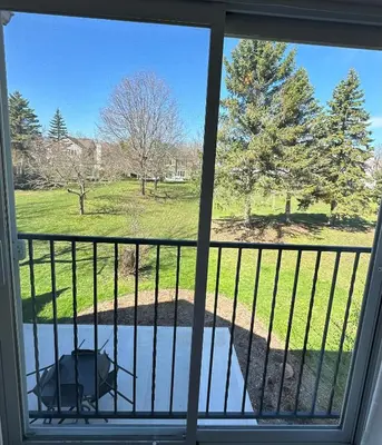 a window view of a dog sitting on a balcony at Golf Spa Relax in Collingwood