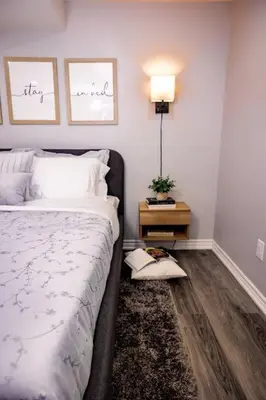 a bedroom with a bed and a table with a lamp at French Charm in Brampton 2 Bdrm Apt in Brampton