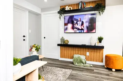 a living room with a couch and a tv on a wall at French Charm in Brampton 2 Bdrm Apt in Brampton
