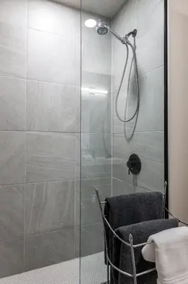 a shower with a glass door in a bathroom at Glyn Rhosyn Loft in Stratford